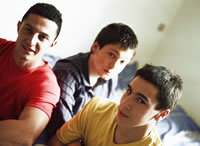 drei Jungen sitzen auf einem Bett