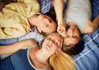 drei Mädchen liegen auf einem Bett